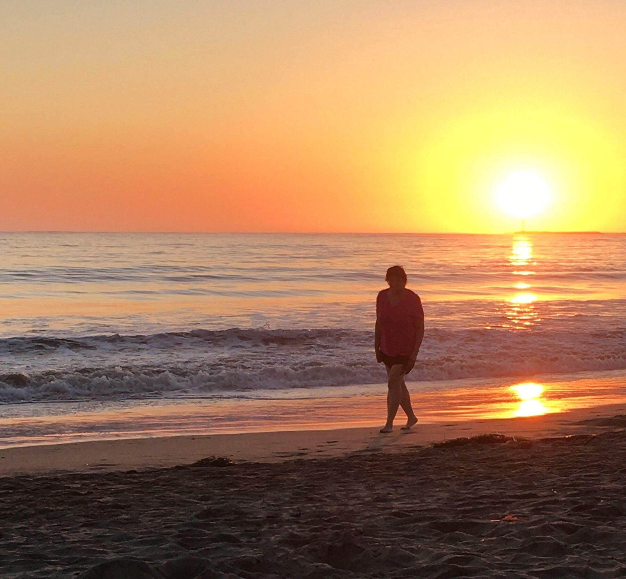 Reflection at sunset Kristi Pederson walking barefoot along the shoreline at sunset.